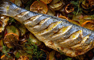 Sustainably line caught British sea bass cooked on a bed of potatoes, lemons and garlic. 