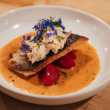 Wild Seabass Fillet on a bed of Isle of White Tomatoes in a Crab and Lemon Grass Sauce