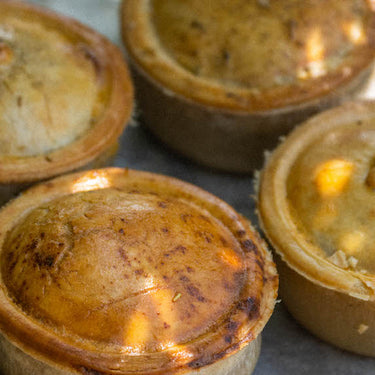 Four cooked pies on a tray