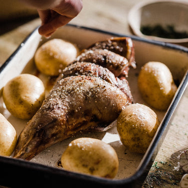 A cooked Grass Fed Lamb Roasting Joint on an oven tray.