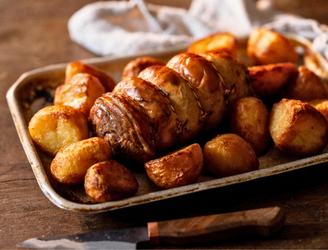 A cooked properly free range boneless turkey leg with roast potatoes