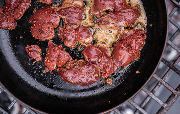 Properly Free Range Chicken Livers cooking in a pan with chilli flakes and seasonings.