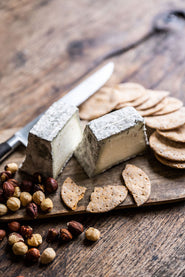 Pave cobble cheese with biscuits and nuts on a board
